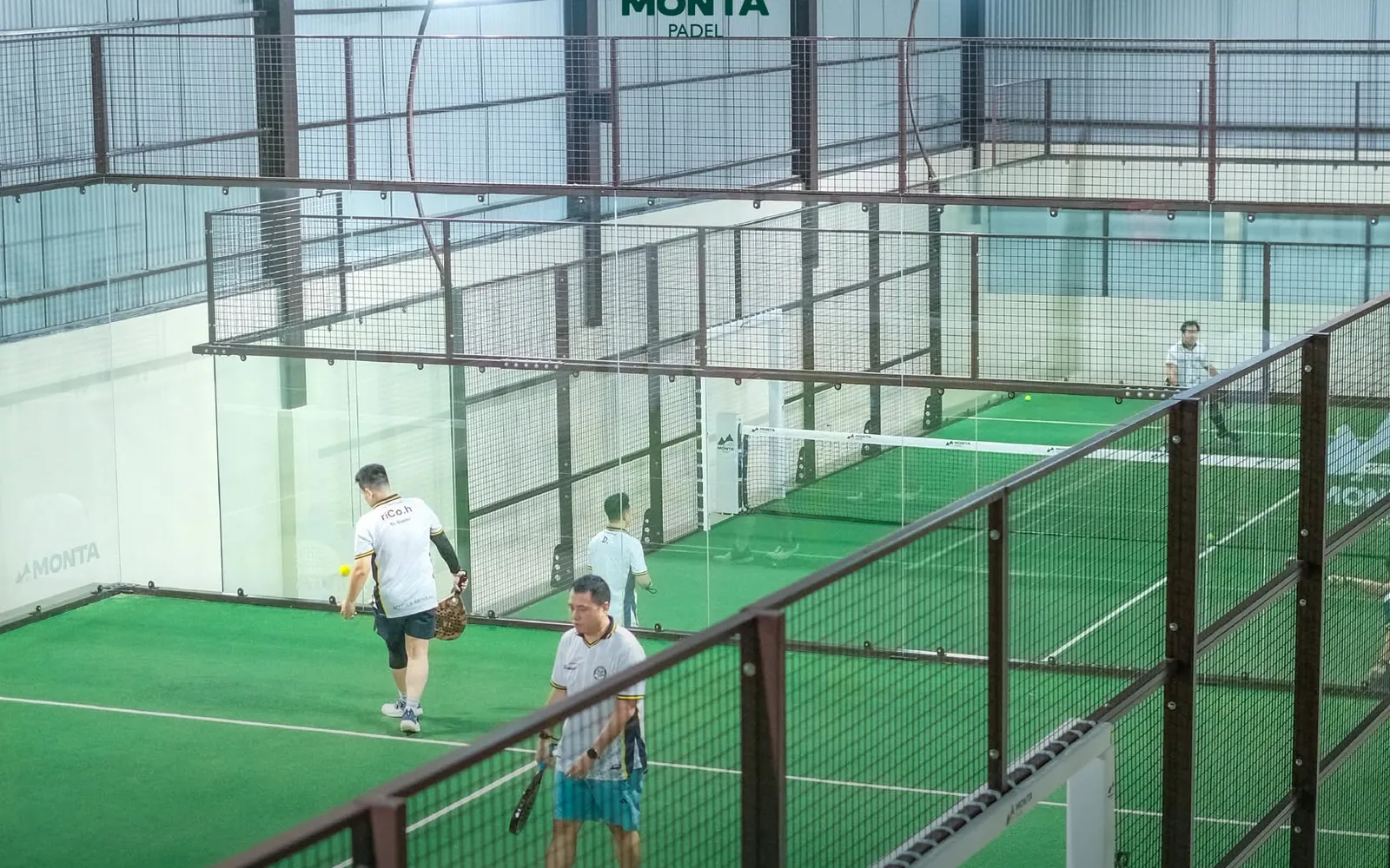 Looking down from the upper level onto a court below, with players mid-game
