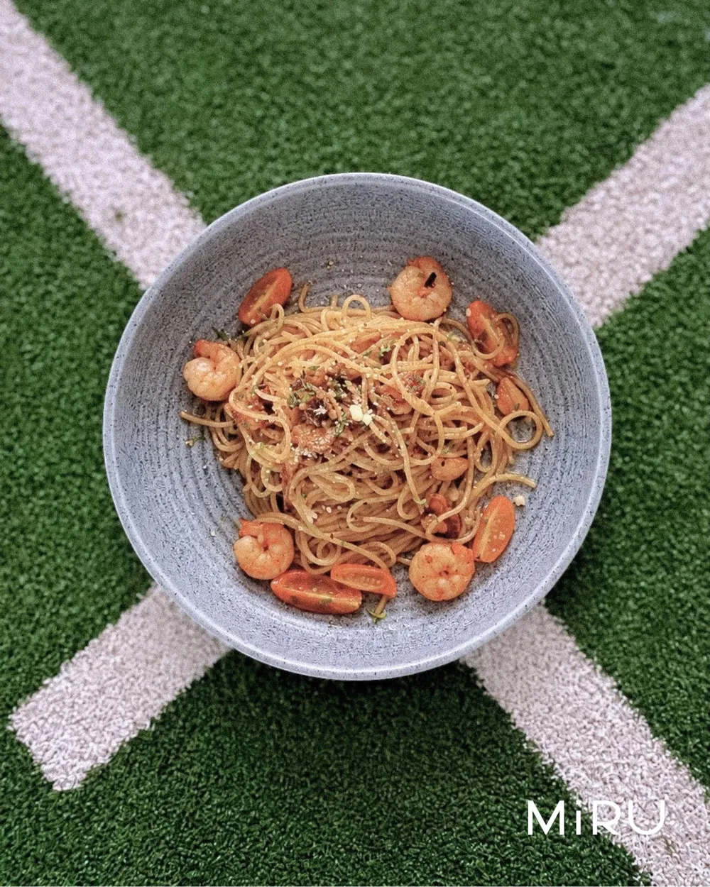 A bowl of prawn spaghetti set on the court lines